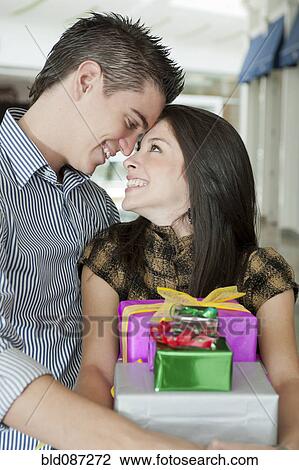 Hispanic couple holding wrapped gifts View Large Photo Image Stock Image - Hispanic couple holding wrapped gifts. Fotosearch