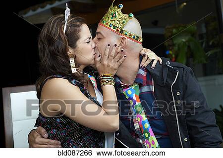 Stock Photograph - Hispanic couple kissing at party. Fotosearch