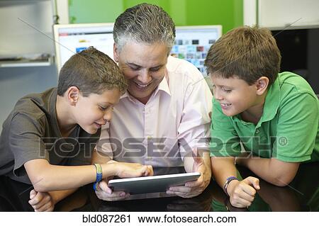 Hispanic father and sons using digital tablet View Large Photo Image Stock Image - Hispanic father and sons using digital tablet. Fotosearch