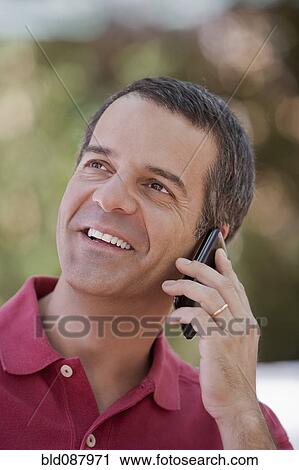Stock Image - Hispanic man talking on cell phone. Fotosearch
