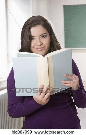Stock Photo - Hispanic teenage girl reading book. Fotosearch