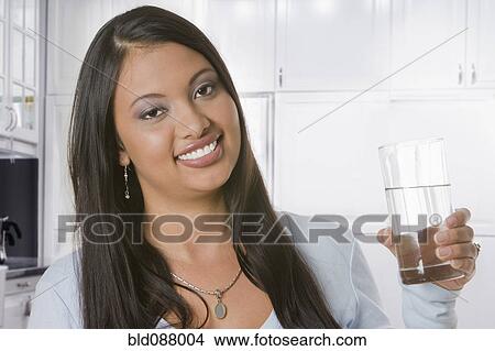 Picture - Hispanic woman drinking water. Fotosearch