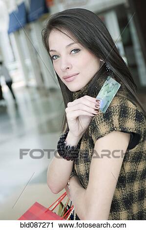 Stock Image - Hispanic woman holding credit card. Fotosearch