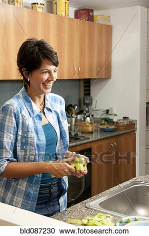 Hispanic woman peeling apple in kitchen View Large Photo Image Stock Image - Hispanic woman peeling apple in kitchen. Fotosearch