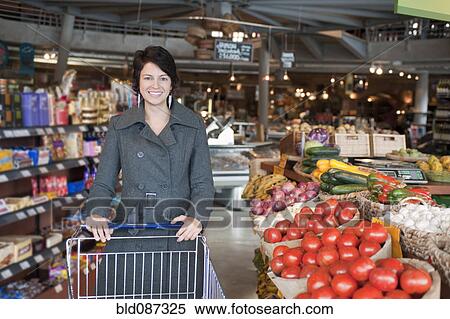 Stock Photography - Hispanic woman shopping in grocery store. Fotosearch
