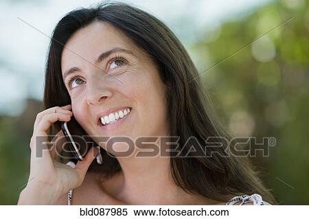 Stock Photography - Hispanic woman talking on cell phone. Fotosearch