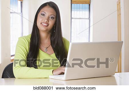 Hispanic woman typing on laptop View Large Photo Image Stock Image - Hispanic woman typing on laptop. Fotosearch