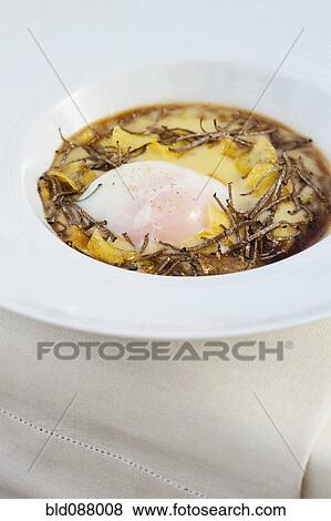 Stock Photo - Italian entree of egg, polenta and truffles. Fotosearch