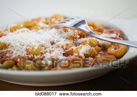 Stock Photo - Italian gnocchi with parmesan cheese and tomato sauce. Fotosearch