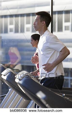 Man running on treadmill in health club View Large Photo Image Stock Photograph - Man running on treadmill in health club. Fotosearch