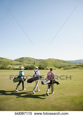 Men carrying golf bags on golf course View Large Photo Image Stock Photography - Men carrying golf bags on golf course. Fotosearch