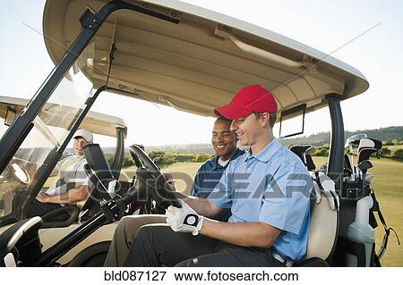 Men driving golf carts on golf course View Large Photo Image Stock Photo - Men driving golf carts on golf course. Fotosearch