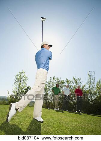 Picture - Men playing golf together on golf course. Fotosearch
