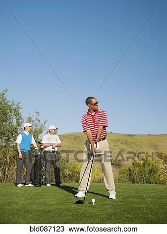 Men playing golf together on golf course View Large Photo Image Stock Image - Men playing golf together on golf course. Fotosearch