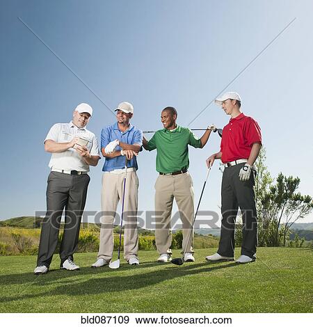Stock Photo - Men playing golf together on golf course. Fotosearch