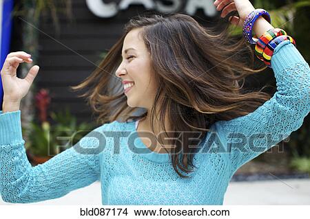 Picture - Mixed race woman dancing outdoors. Fotosearch