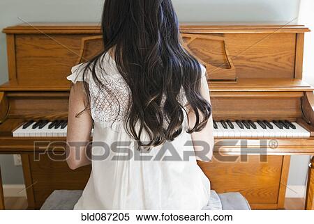 Stock Photography - Mixed race woman playing piano. Fotosearch