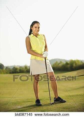 Mixed race woman standing on golf course with golf club View Large Photo Image Stock Photography - Mixed race woman standing on golf course with golf club. Fotosearch