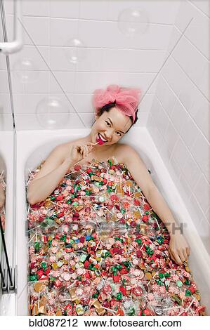 Mixed race woman taking a bath in candy View Large Photo Image Stock Image - Mixed race woman taking a bath in candy. Fotosearch