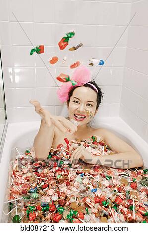 Mixed race woman taking a bath in candy View Large Photo Image Stock Image - Mixed race woman taking a bath in candy. Fotosearch