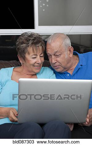 Senior Hispanic couple looking at laptop View Large Photo Image Stock Image - Senior Hispanic couple looking at laptop. Fotosearch