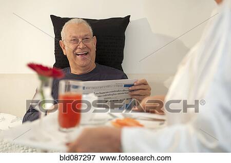 Senior Hispanic woman bringing husband breakfast in bed View Large Photo Image Stock Photo - Senior Hispanic woman bringing husband breakfast in bed. Fotosearch