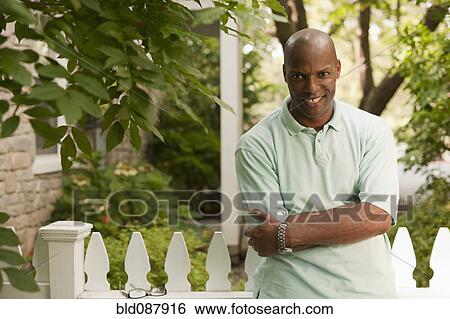 Smiling African American man standing outdoors View Large Photo Image Stock Photograph - Smiling African American man standing outdoors. Fotosearch