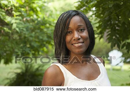 Smiling African American woman standing outdoors View Large Photo Image Stock Photography - Smiling African American woman standing outdoors. Fotosearch