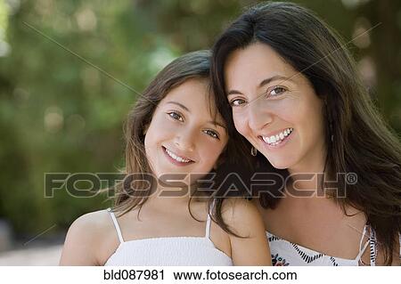 Stock Image - Smiling Hispanic mother and daughter. Fotosearch
