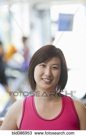 Stock Image - Smiling Korean woman in health club. Fotosearch