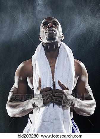 Stock Image - African American athlete standing under lights. Fotosearch