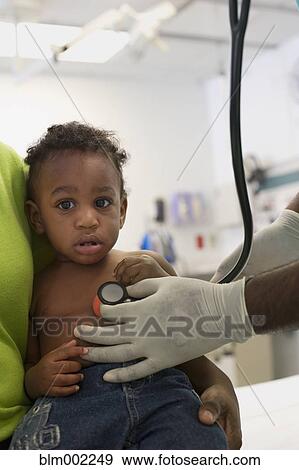 Stock Photo - African American baby being examined at hospital. Fotosearch