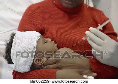 Stock Photo - African American baby getting shot at hospital. Fotosearch