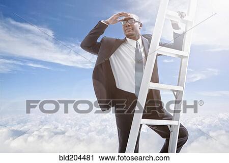 Stock Image - African American businessman climbing ladder. Fotosearch