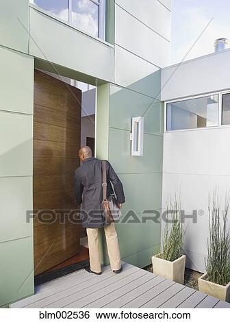 Stock Photograph - African American businessman entering home. Fotosearch