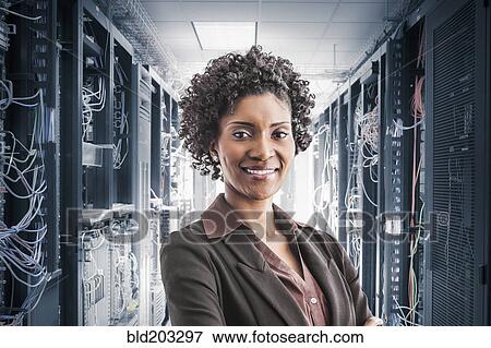 Stock Photo - African American businesswoman smiling in server room. Fotosearch