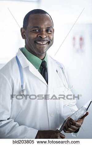 Stock Photography - African American doctor smiling in office. Fotosearch