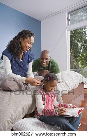 Stock Photo - African American family relaxing in bedroom. Fotosearch