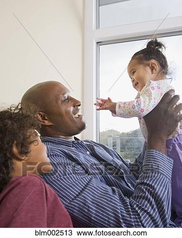 Stock Image - African American father playing with children. Fotosearch