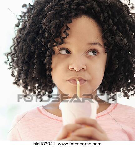 Stock Image - African American girl drinking with straw. Fotosearch