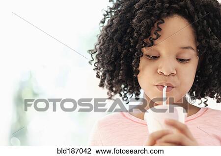 Stock Image - African American girl drinking with straw. Fotosearch