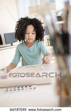 Stock Photo - African American girl painting with watercolors. Fotosearch