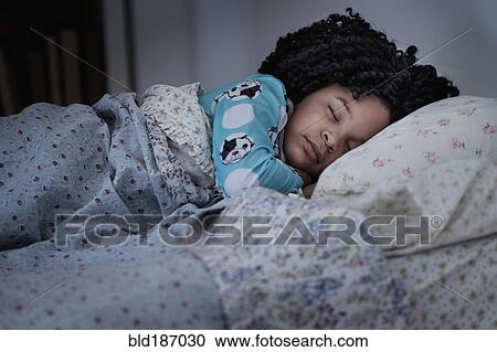 Stock Image - African American girl sleeping in bed. Fotosearch