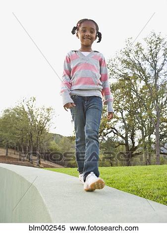 Stock Photography - African American girl walking outdoors. Fotosearch
