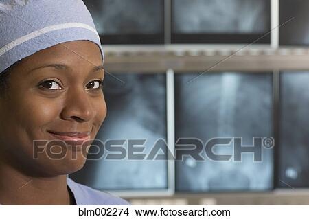 Picture - African American medical professional in front of x-rays. Fotosearch
