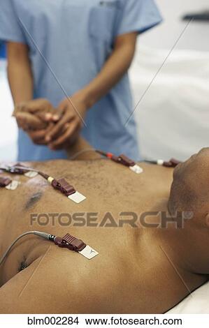 Picture - African American medical professional holding patient's hand. Fotosearch