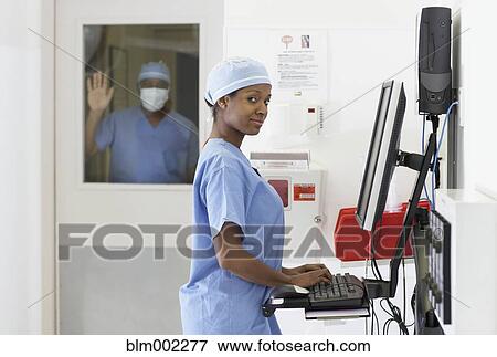 Stock Photo - African American medical professional looking at computer. Fotosearch