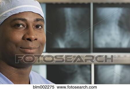 Stock Photography - African American medical professional in front of x-rays. Fotosearch
