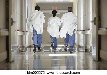 Stock Image - African American medical professionals running in hallway. Fotosearch