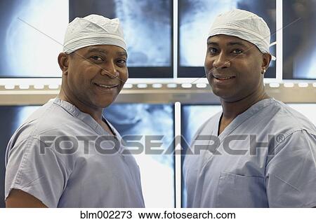 Stock Image - African American medical professionals in front of x-rays. Fotosearch